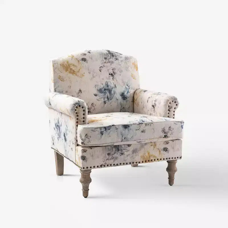 Fauteuil rembourré en bois avec motif floral, accoudoirs à panneaux et dossier en forme de bosse de chameau.